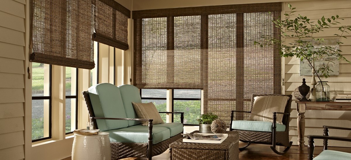 formal living room with rattan furniture and woven wood blinds on the windows