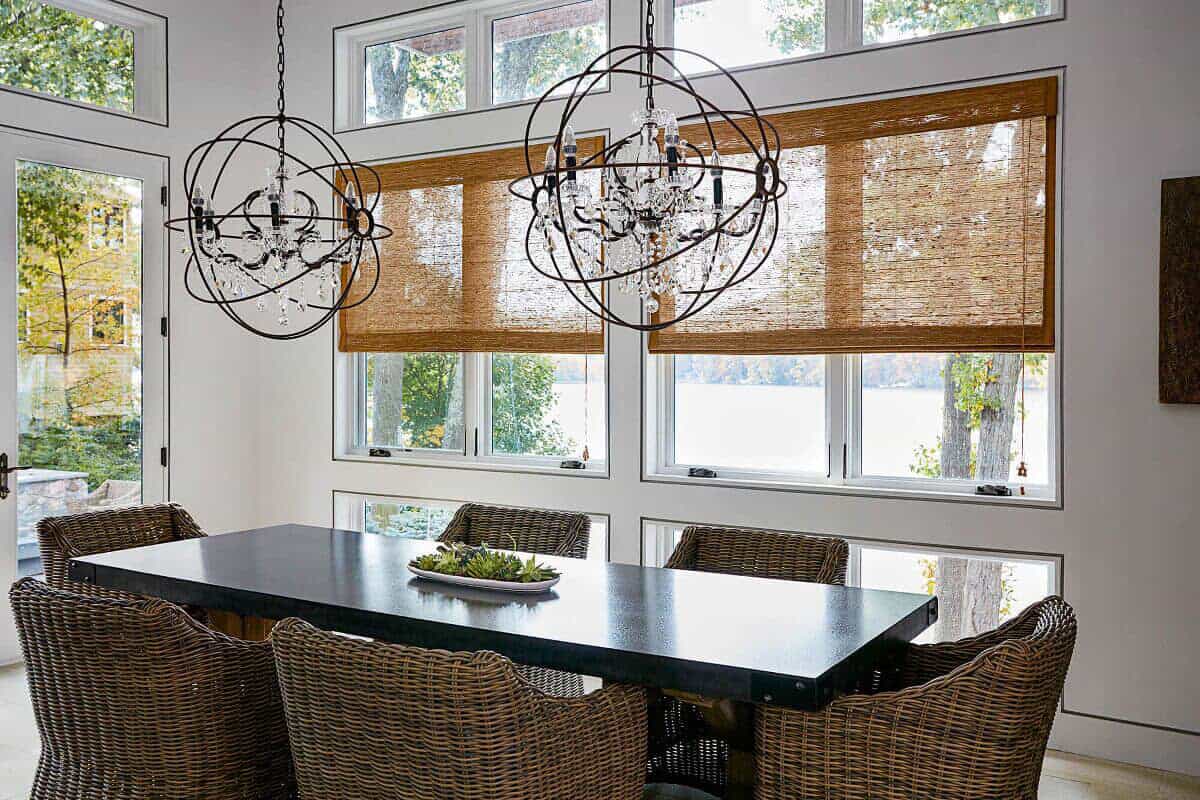 dining room with dark rattan chairs and light tan bamboo blinds on windows