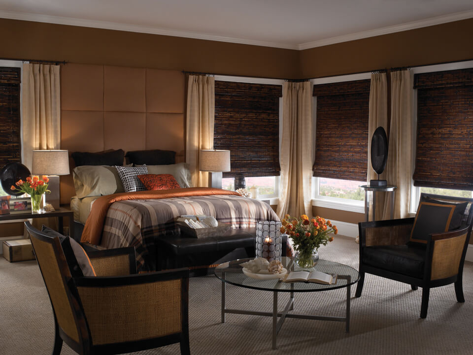 formal bedroom with dark brown woven wood blinds and beige drapes