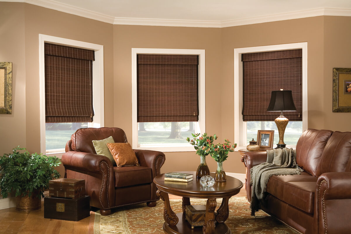 living room with leather chairs and wood coffee table; dark woven wood blinds on windows