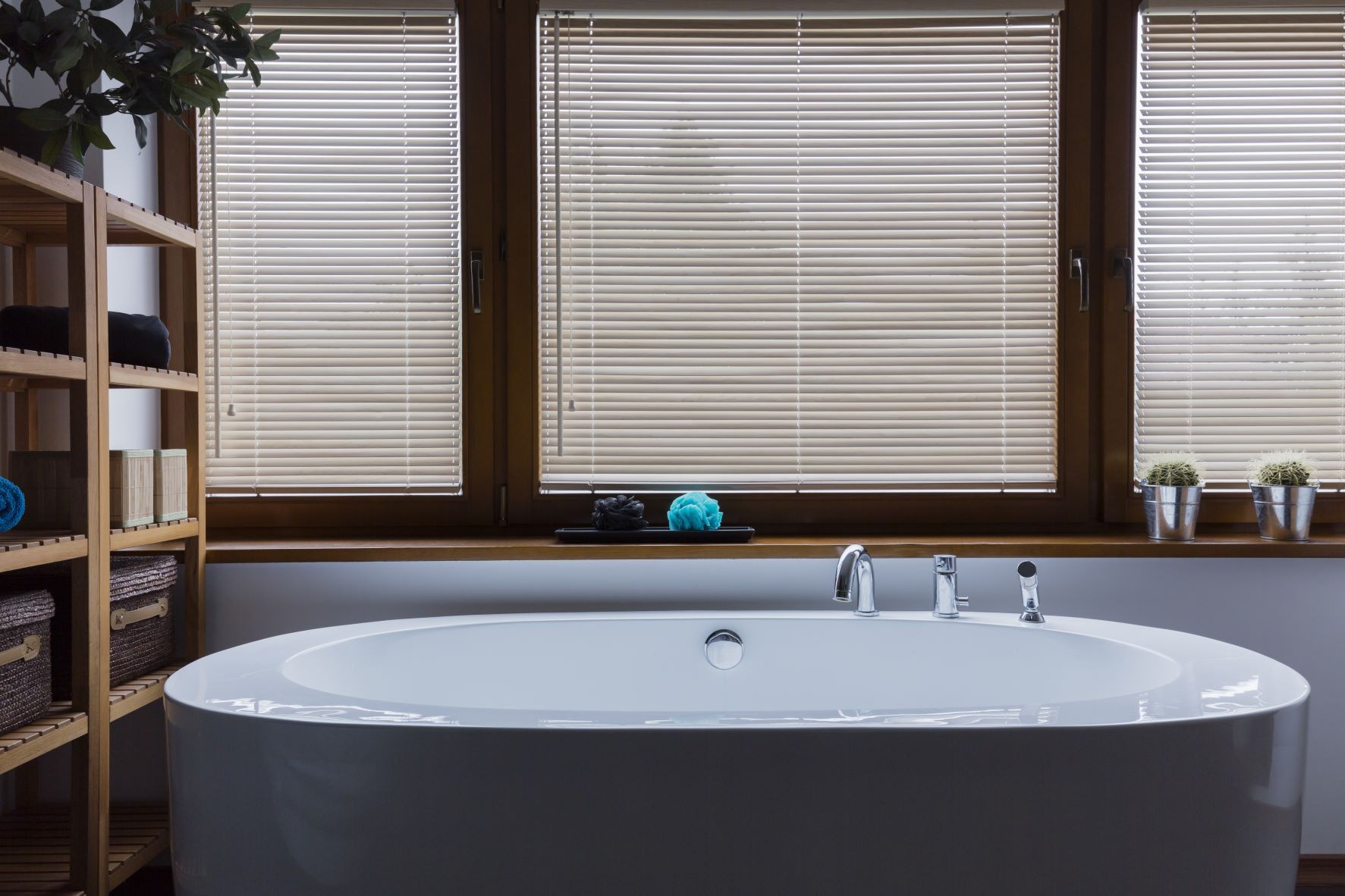 windows with closed venetian blinds over a large tub