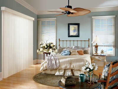Three sets of white blinds in a beautiful bedroom