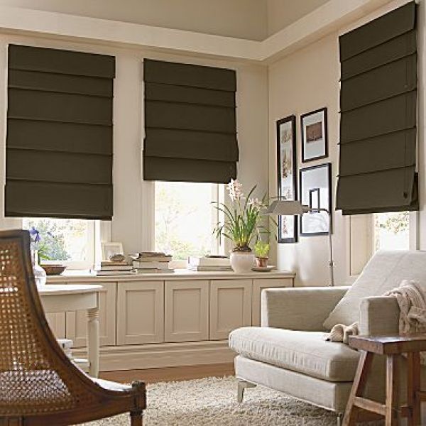 Dark gray window shades on three windows in a living area