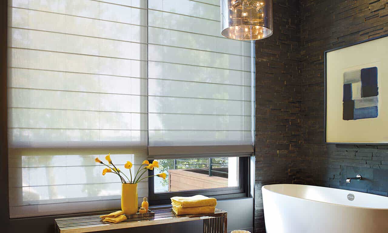 room with rattan chair at a table and woven wood shades on windows